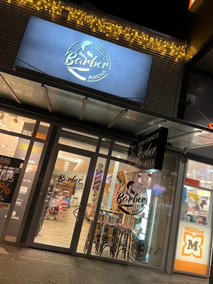 Barber Shop Arena von außen am Abend, das Schild über dem Eingang leuchtet