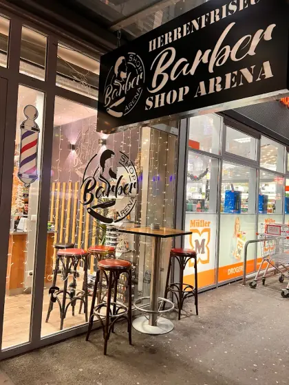 Eingang mit Barber-Säule, Schild Herrenfriseur Barber Shop Arena und Barhockern